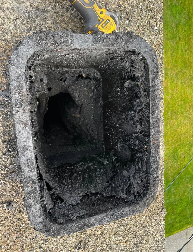 Heavy creosote buildup inside a chimney flue before cleaning