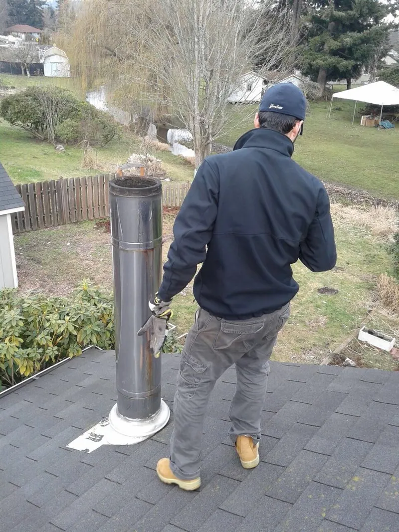Seattle Chimney Services technician preparing a chimney sweep on a roof